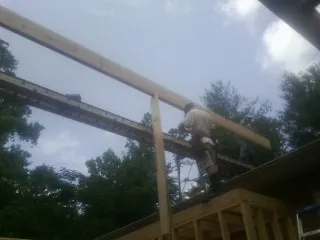 Carpenter setting a ridge beam over a new addition frame — Ice Dam Removal by Roofing Brothers in Breaux Bridge
