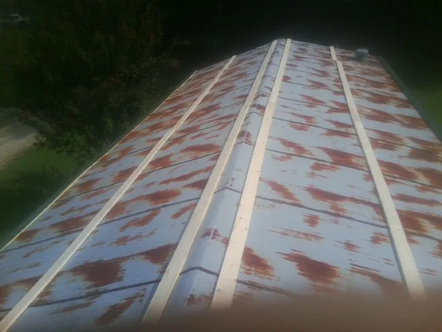 Rusted metal roof panels with new wood purlins before replacement — Storm Damage Roof Repair in Breaux Bridge by Roofing Brothers