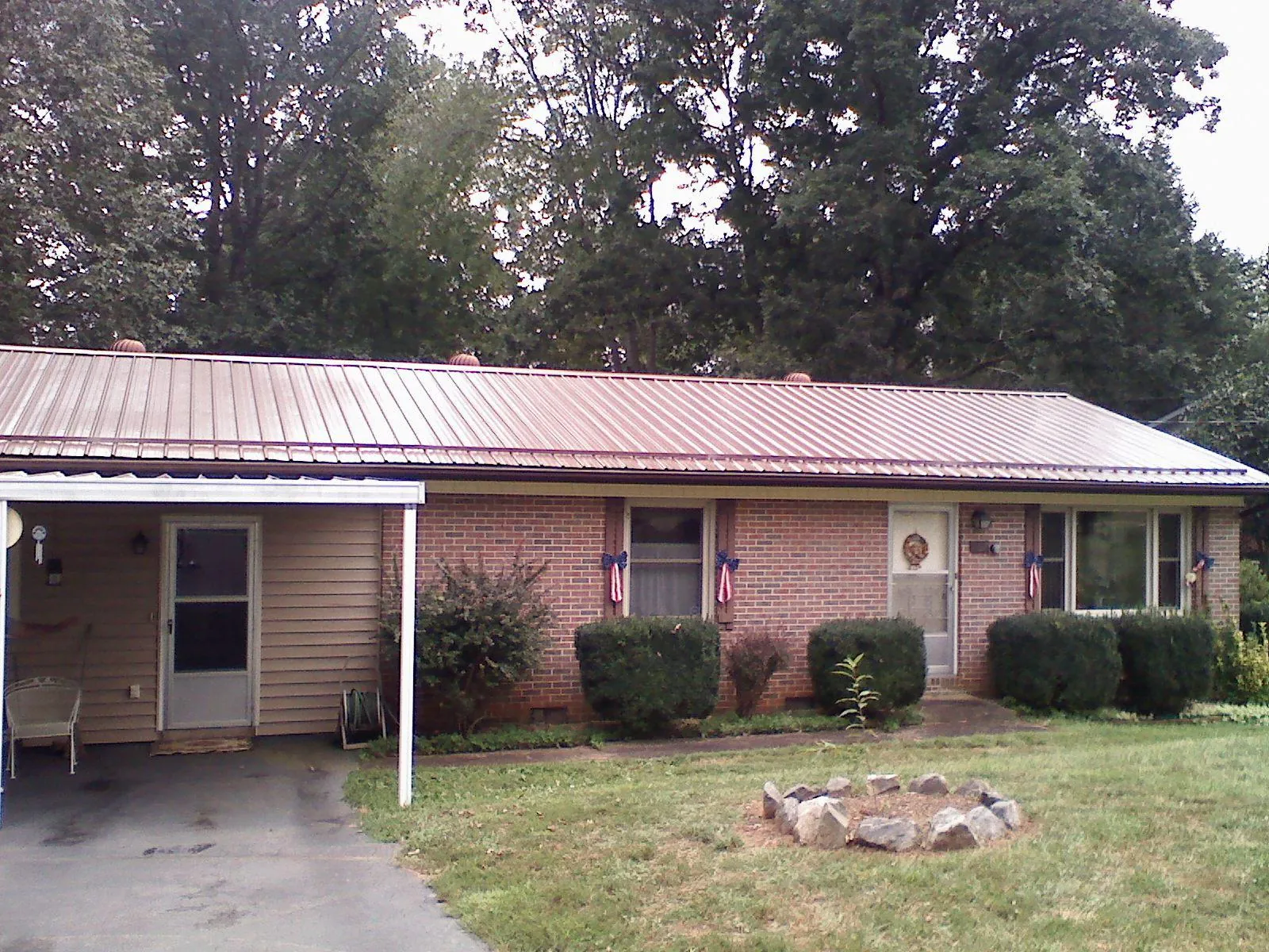 Bronze metal roof and carport on a brick ranch home — Roof Repair work by our crew in Breaux Bridge