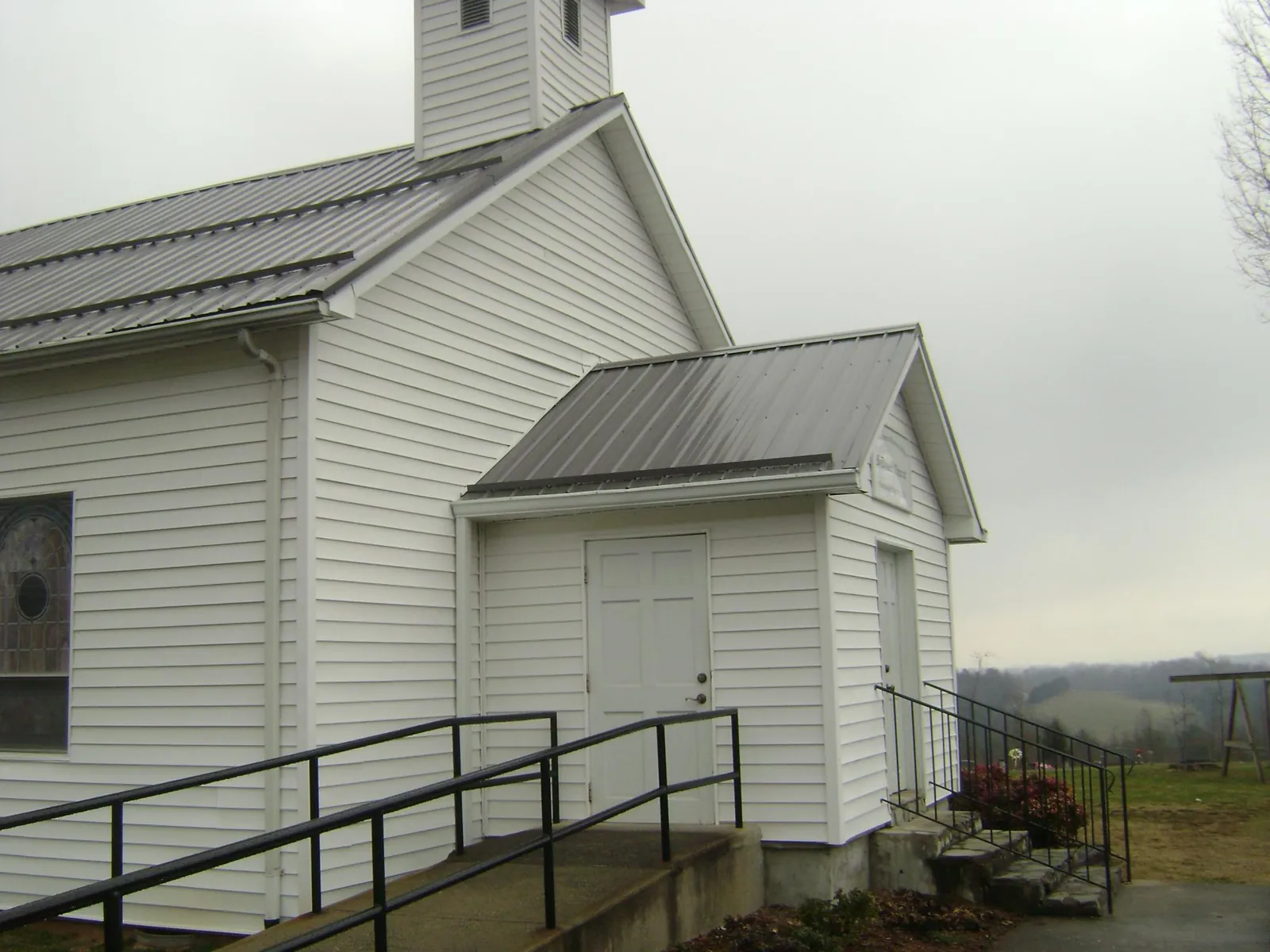 Gray metal roof on a white clapboard church with a steeple in Breaux Bridge