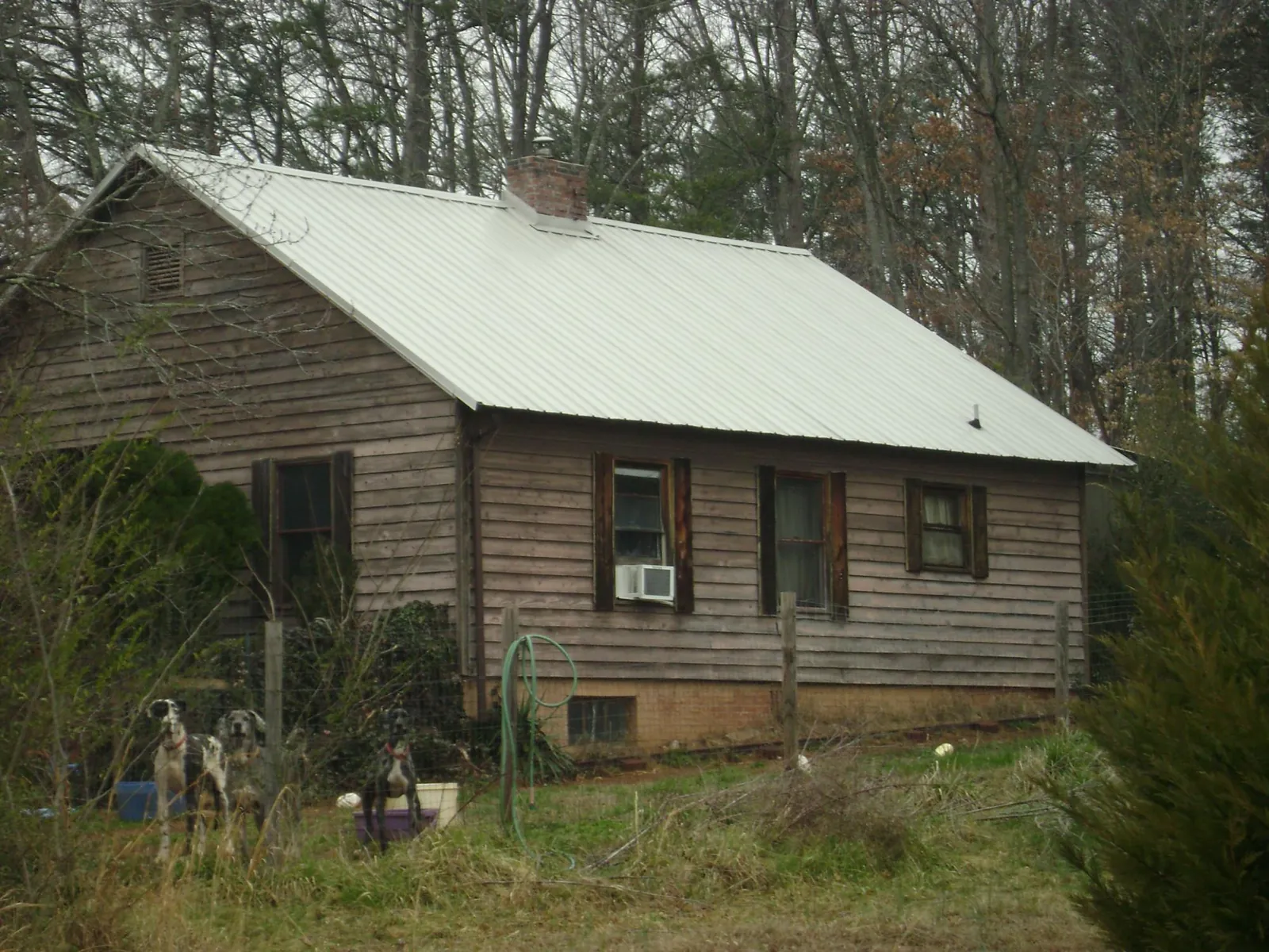 White metal roof on an old wood sided farmhouse, from a Metal Roof Installation job in Breaux Bridge